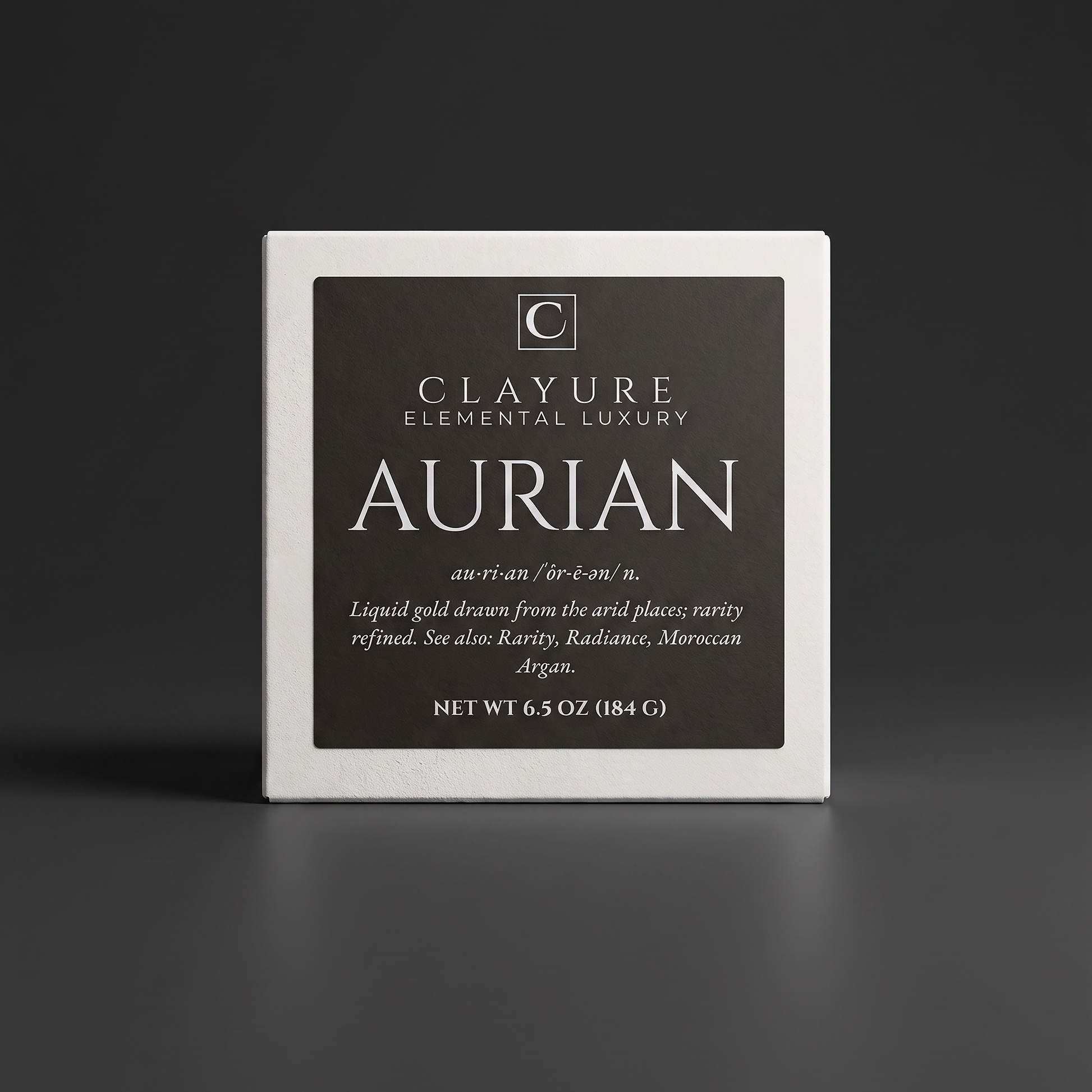 A square white bar of soap with a dark charcoal label reading 'Clayure Elemental Luxury Aurian' on a dark gray studio background.