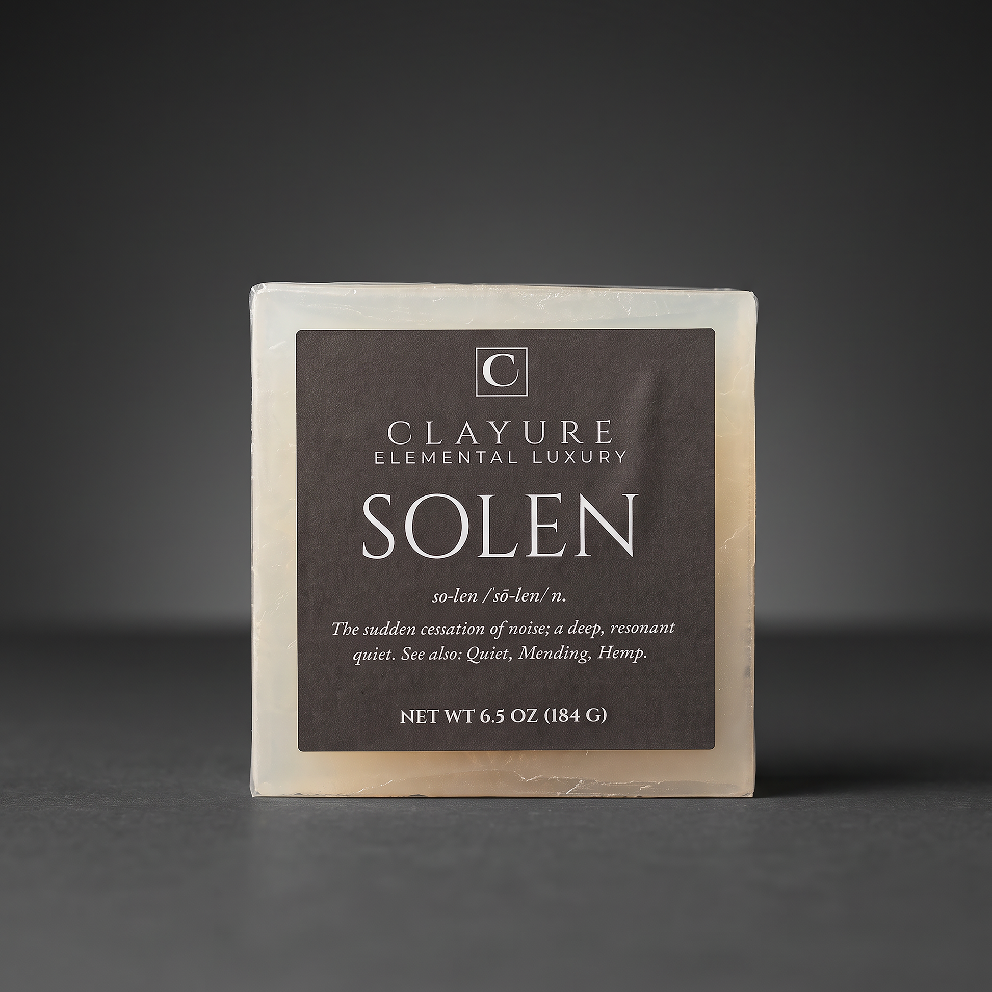 A square bar of Clayure Hemp soap named 'Solen' on a dark gray background. The soap has a dark brown label with white text and a light beige soap body visible around the edges.
